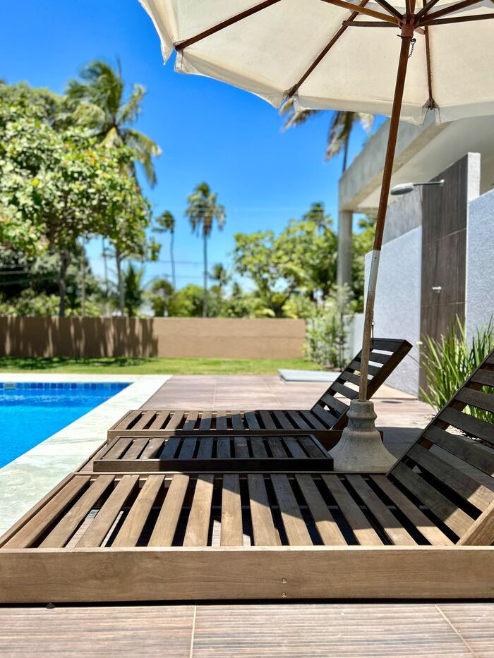 Espreguiçadeiras e guarda-sol à beira da piscina