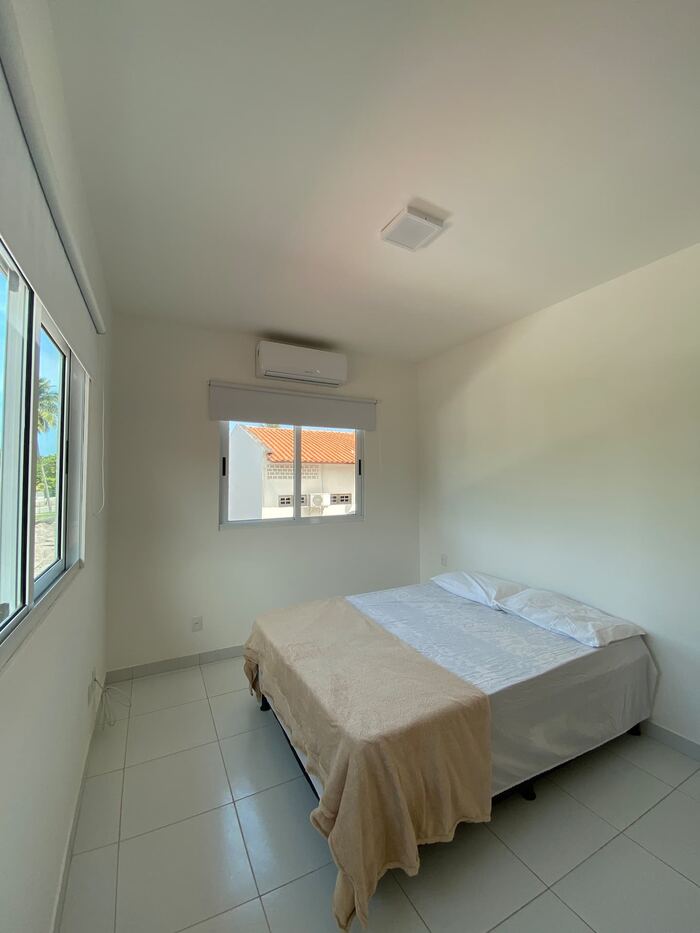 Quarto com cama de casal e janelas amplas